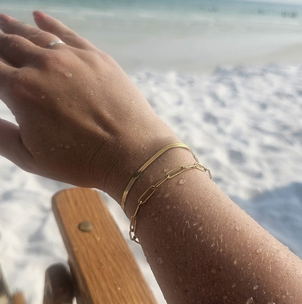 person on beach wearing gold bracelets