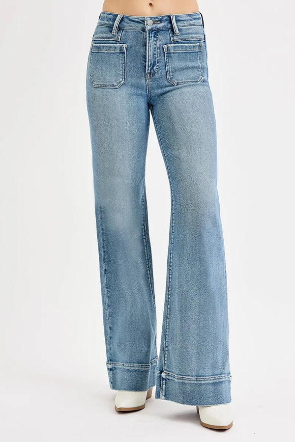 person wearing medium wash flare jeans with front pockets and white boots
