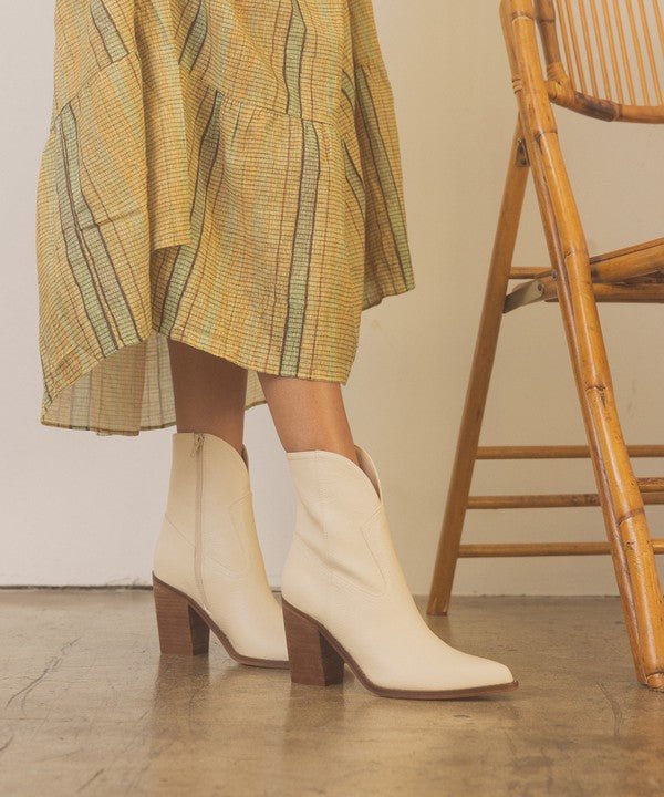 woman wearing yellow dress and bone colored leather block heel booties