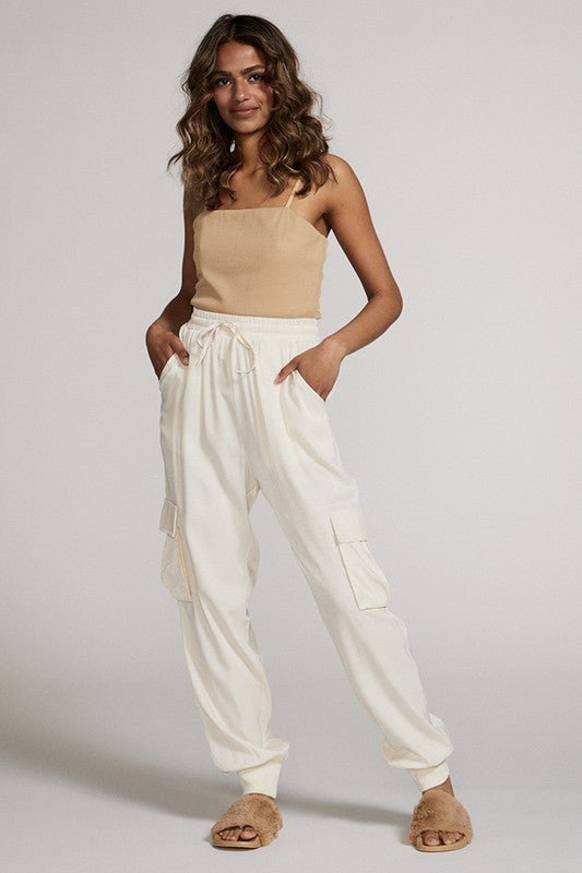 woman wearing comfortable cream colored jogger pants with chic beige tank top