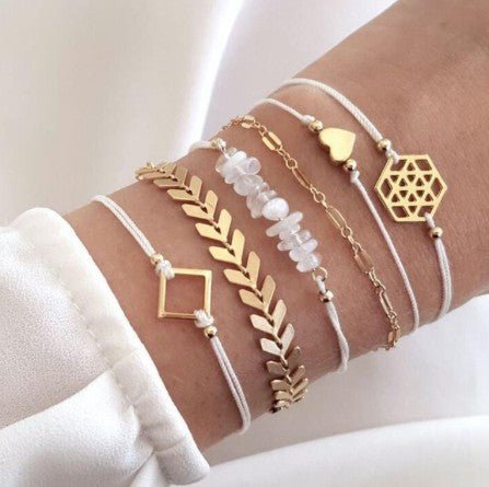 person wearing stacked gold boho design bracelets