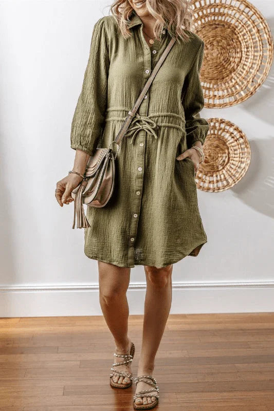 woman wearing a boho-chic style olive green collared shirt dress with 3/4 length sleeves