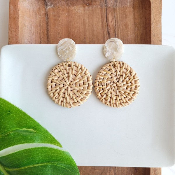 rattan stud earrings with a white and wood background