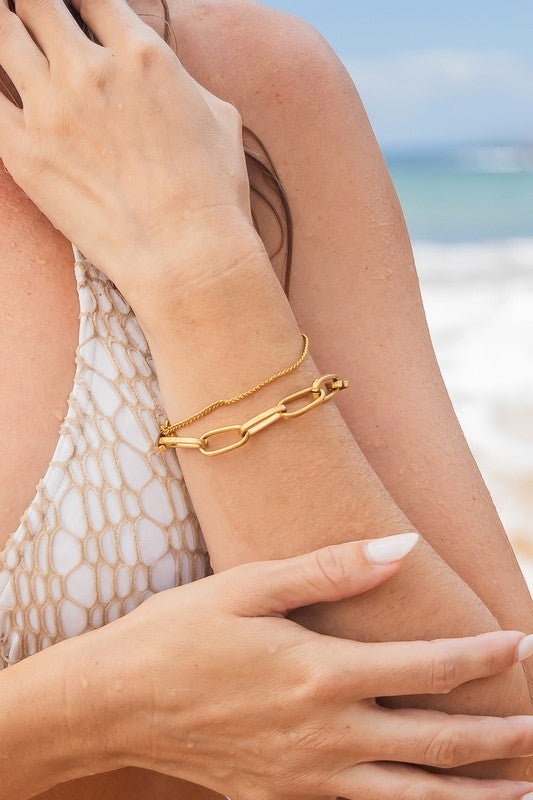 woman on beach, wearing rust-free layered gold bracelets