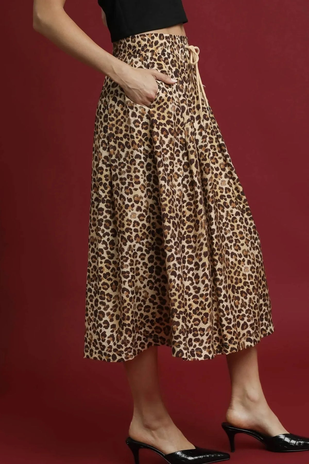 woman wearing leopard print midi skirt with pockets and black kitten heels