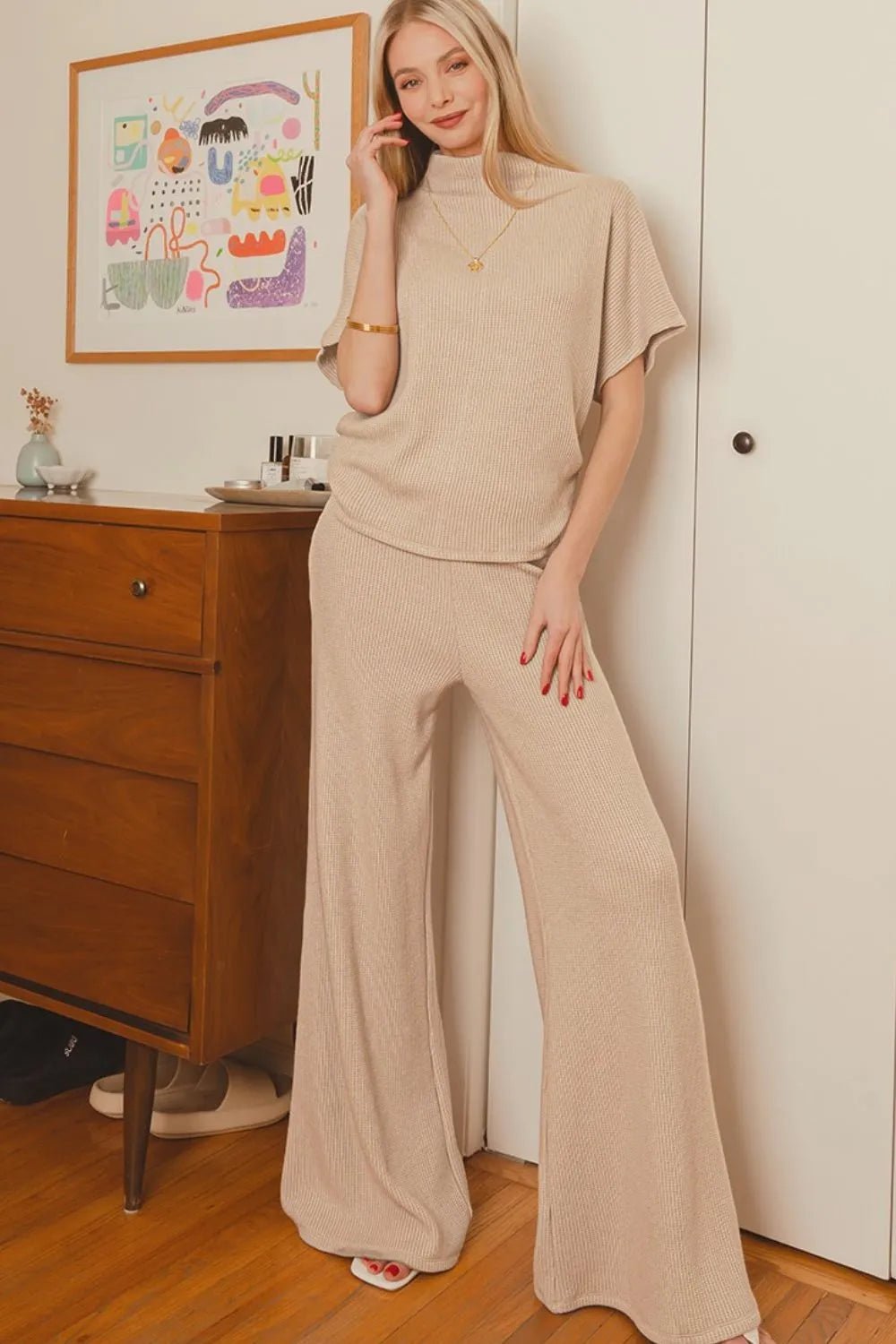 woman standing in room wearing beige loungewear outfit set