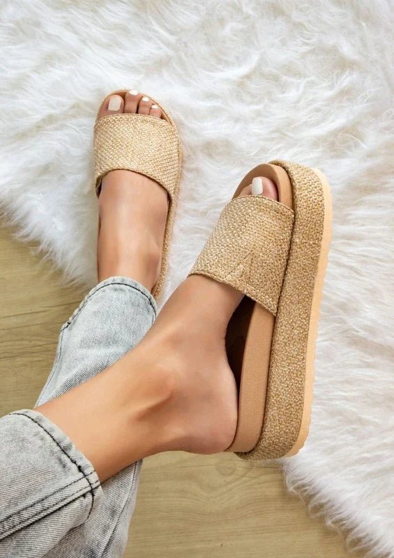 women wearing jeans and beige color woven platform slide-on sandals over fluffy white carpet