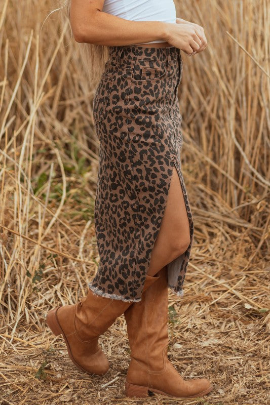 person standing in field wearing leopard print midi skirt and brown mid calf boots