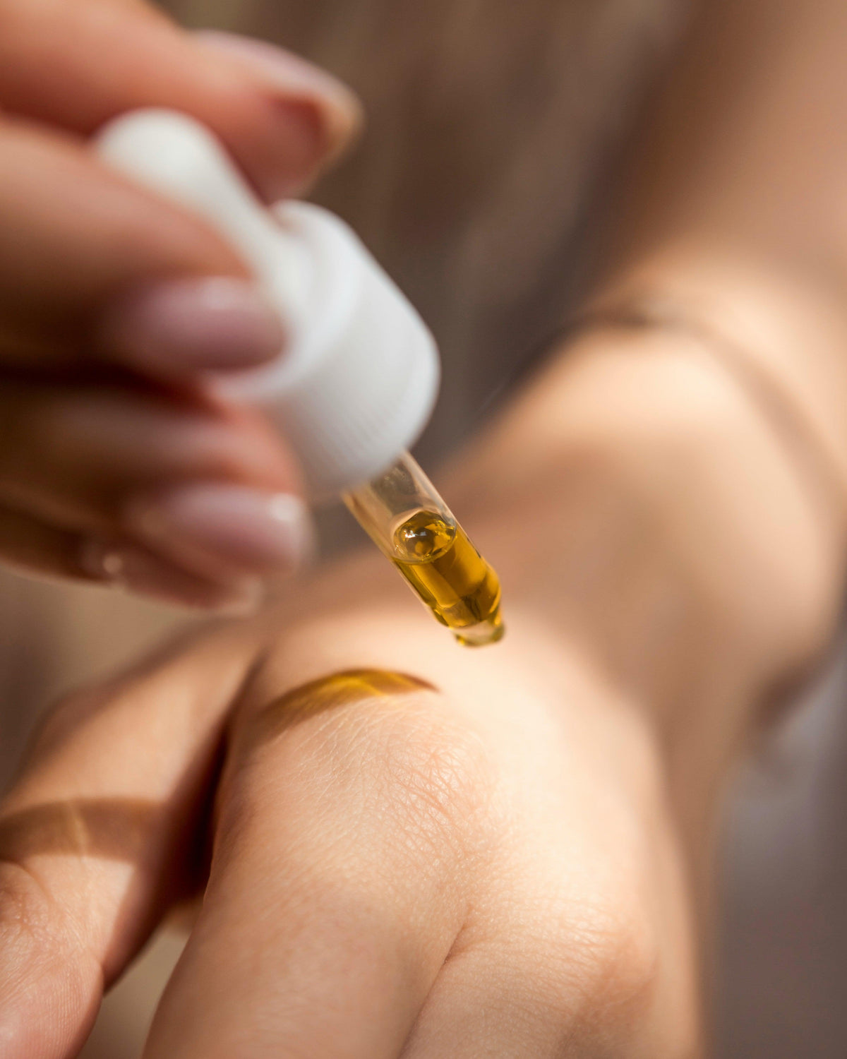 natural skincare oil in dropper being put on hand
