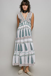 Ivory V-neck sleeveless tiered dress with green leafy floral print, smocked waistband, and ruffle accents.