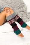 Leg warmers with a pattern worn by a person sitting on a white surface.