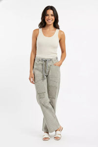 Woman wearing a sleeveless top and striped pants on a white background