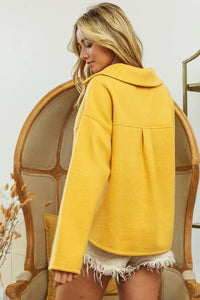Woman wearing Honey Mustard Fleece Collared Sweatshirt-Fleece collared sweatshirt with flap pockets and button details. Cozy, stylish, and perfect for layering all season long, your new cozy fall favorite.