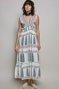 Ivory V-neck sleeveless tiered dress with green leafy floral print, smocked waistband, and ruffle accents.