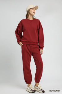 Burgundy Sweatshirt with Pleated Detail-Cozy meets chic in this burgundy pleated sweatshirt. A fall-ready round neck pullover with soft sleeve details, perfect for layering or lounging. Sizes XS–L.-Reef Love Boutique