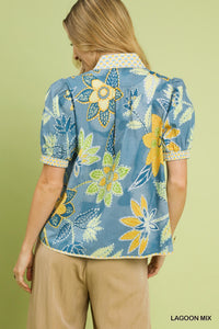 Vibrant blue cotton blouse with yellow and green floral print, puff sleeves, and unique collar detail.