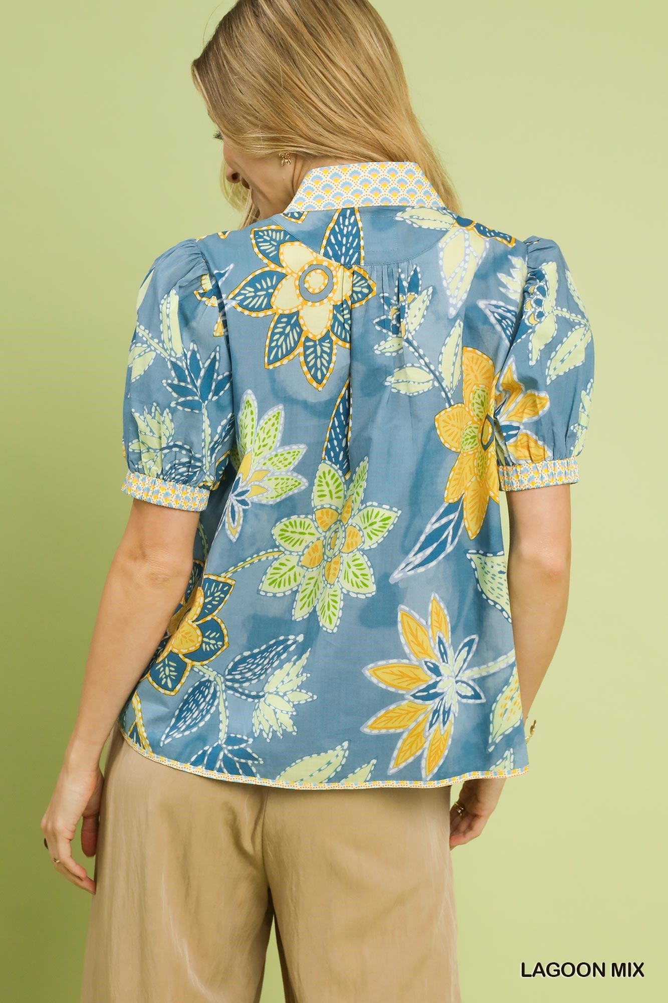 Vibrant blue cotton blouse with yellow and green floral print, puff sleeves, and unique collar detail.