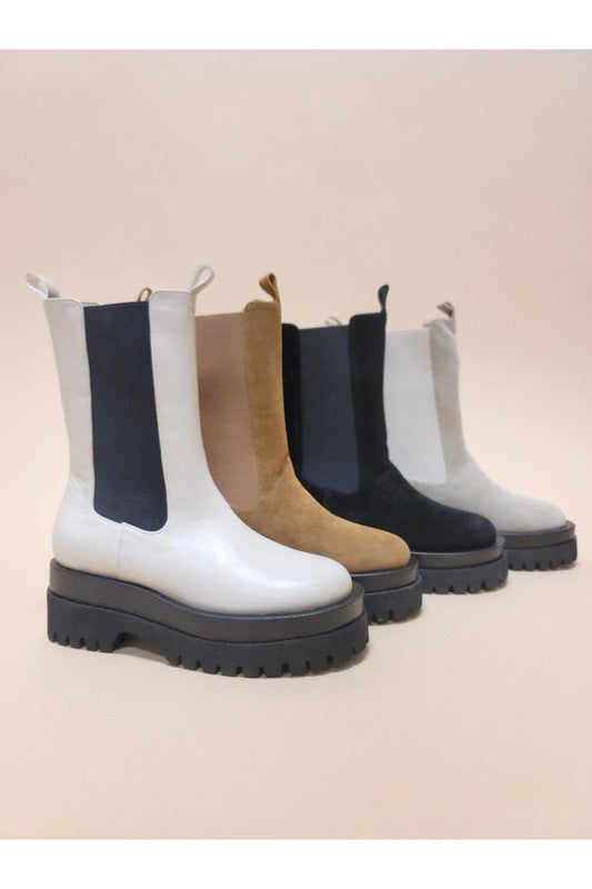 Set of five different colored boots on a beige background