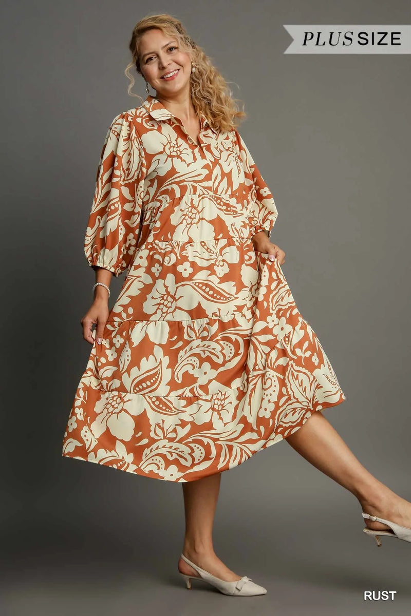 Woman wearing Floral Tiered Midi Shirt Dress-Flowy floral tiered midi shirt dress with 3/4 sleeves in rust + beige print. Boho-chic style in standard & plus sizes for casual or dressy days.