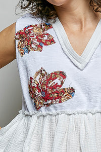 White POL Floral Patch Ruffled Sleeveless Top with V-neck, raw edge detail, and bohemian-inspired floral patches.