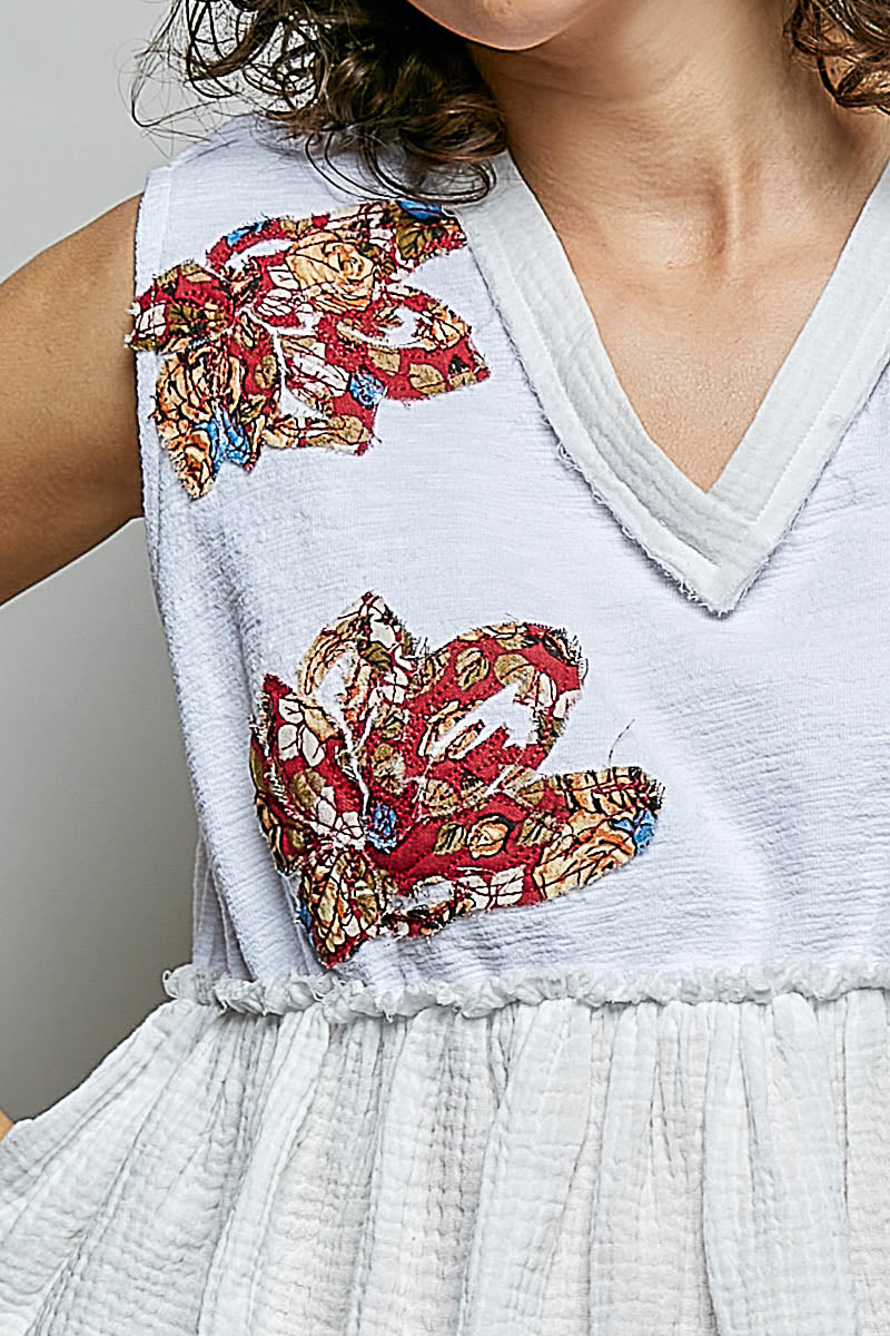 White POL Floral Patch Ruffled Sleeveless Top with V-neck, raw edge detail, and bohemian-inspired floral patches.