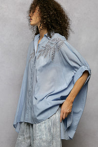 Sky blue 100% cotton POL button-down shirt with intricate leaf embroidery, voluminous sleeves, and a high-low hem.