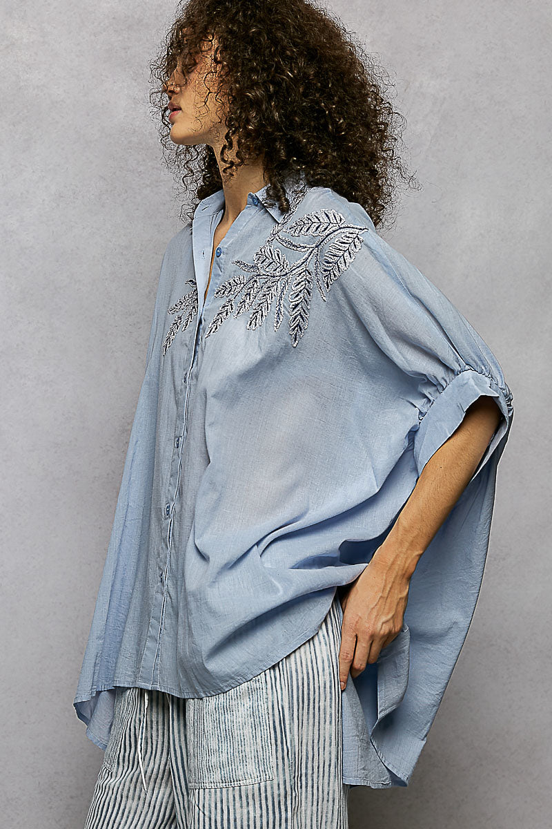 Sky blue 100% cotton POL button-down shirt with intricate leaf embroidery, voluminous sleeves, and a high-low hem.