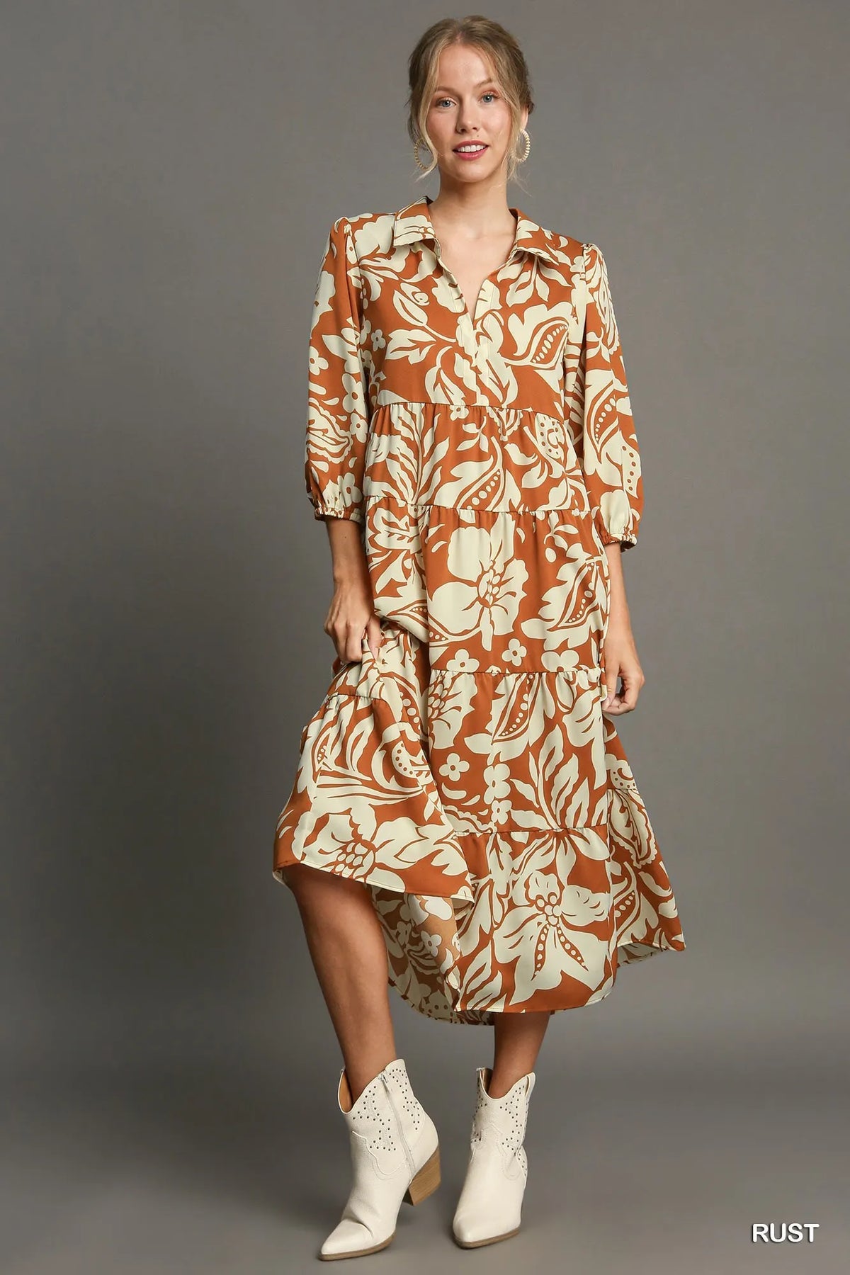 Woman wearing Floral Tiered Midi Shirt Dress-Flowy floral tiered midi shirt dress with 3/4 sleeves in rust + beige print. Boho-chic style in standard & plus sizes for casual or dressy days.