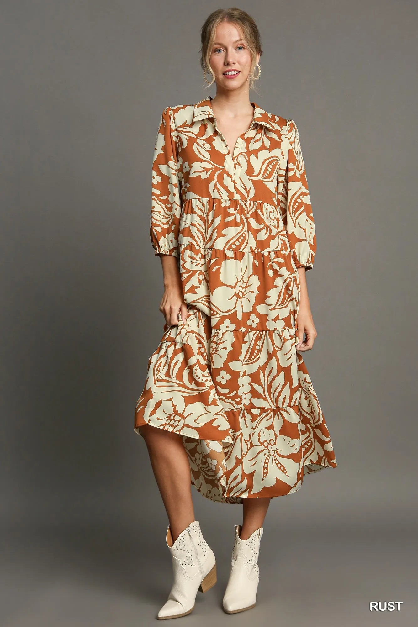Woman wearing Floral Tiered Midi Shirt Dress-Flowy floral tiered midi shirt dress with 3/4 sleeves in rust + beige print. Boho-chic style in standard & plus sizes for casual or dressy days.