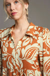 Woman wearing Floral Tiered Midi Shirt Dress-Flowy floral tiered midi shirt dress with 3/4 sleeves in rust + beige print. Boho-chic style in standard & plus sizes for casual or dressy days.