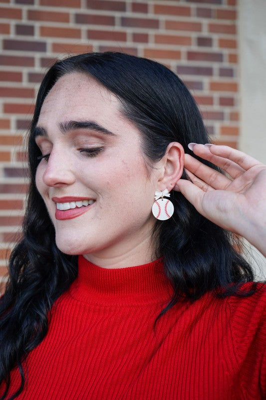 Bow Baseball Earrings-Hit your game day look out of the park with our Game Day Bow Baseball Earrings! Featuring a sweet white bow and a sparkly red-stitched baseball charm.