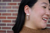 Bow Football Earrings-Football Season Must-have Earrings. Cheer in style with our Game Day Bow Football Earrings! Featuring a dainty white bow paired with a glittery brown football.