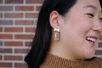 Bow Football Earrings-Football Season Must-have Earrings. Cheer in style with our Game Day Bow Football Earrings! Featuring a dainty white bow paired with a glittery brown football.