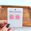 Shop Ghost Studs - Pink Glitter-Pink glitter ghost stud earrings with hypoallergenic posts. Light, sparkly, and spooky-cute—perfect for Halloween or showing off your playful ghost-loving side.-available at Reef Love online boho-chic boutique