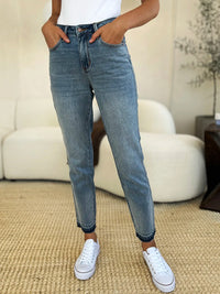 Judy Blue Mid Rise Rigid Magic Release Hem Jeans-Judy Blue Mid Rise Rigid Magic Release Hem Jeans with structured fit + stretch comfort. Trendy release hem. Available in standard & plus sizes.