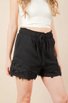 Women's black Lace contrast woven shorts are chic and stylish bottoms that feature delicate lace accents. These shorts combine a woven fabric with lace detailing.
