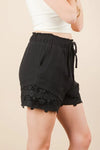 Women's black Lace contrast woven shorts are chic and stylish bottoms that feature delicate lace accents. These shorts combine a woven fabric with lace detailing.