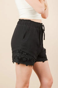 Women's black Lace contrast woven shorts are chic and stylish bottoms that feature delicate lace accents. These shorts combine a woven fabric with lace detailing.