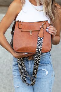 Leopard Strap Fold-over Crossbody Bag-Vegan leather crossbody with leopard strap, snap + zipper closures, and pockets.