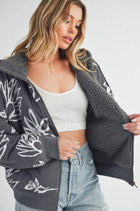 Shop Oita Floral Zip Front Hoodie-Cozy meets cool in the Oita Floral Zip-Up Hoodie - sherpa-lined warmth, bold floral print, and a bomber fit make this your new cold-weather go-to.-available at Reef Love online boho-chic boutique
