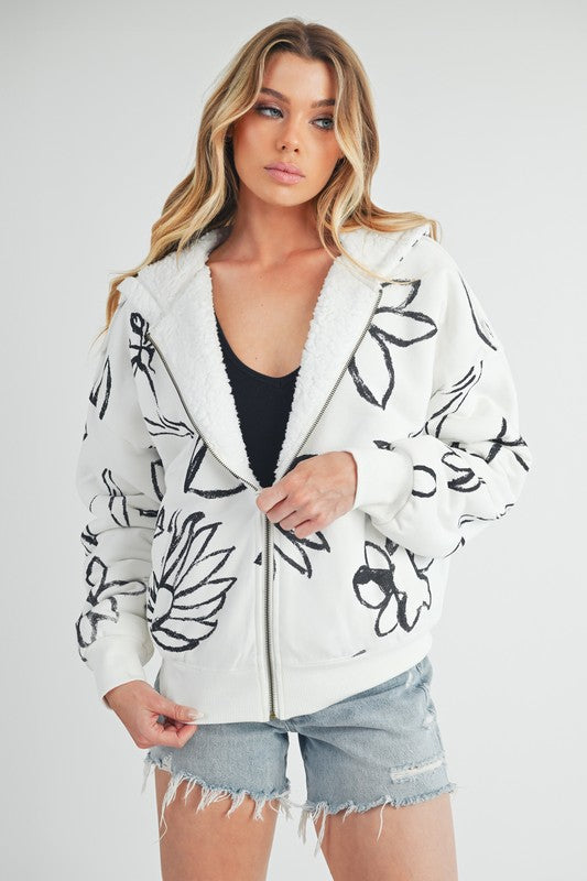 Shop Oita Floral Zip Front Hoodie-Cozy meets cool in the Oita Floral Zip-Up Hoodie - sherpa-lined warmth, bold floral print, and a bomber fit make this your new cold-weather go-to.-available at Reef Love online boho-chic boutique