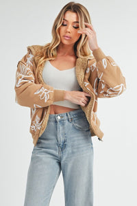 Shop Oita Floral Zip Front Hoodie-Cozy meets cool in the Oita Floral Zip-Up Hoodie - sherpa-lined warmth, bold floral print, and a bomber fit make this your new cold-weather go-to.-available at Reef Love online boho-chic boutique