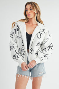 Shop Oita Floral Zip Front Hoodie-Cozy meets cool in the Oita Floral Zip-Up Hoodie - sherpa-lined warmth, bold floral print, and a bomber fit make this your new cold-weather go-to.-available at Reef Love online boho-chic boutique