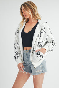 Shop Oita Floral Zip Front Hoodie-Cozy meets cool in the Oita Floral Zip-Up Hoodie - sherpa-lined warmth, bold floral print, and a bomber fit make this your new cold-weather go-to.-available at Reef Love online boho-chic boutique