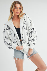 Shop Oita Floral Zip Front Hoodie-Cozy meets cool in the Oita Floral Zip-Up Hoodie - sherpa-lined warmth, bold floral print, and a bomber fit make this your new cold-weather go-to.-available at Reef Love online boho-chic boutique