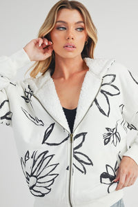 Shop Oita Floral Zip Front Hoodie-Cozy meets cool in the Oita Floral Zip-Up Hoodie - sherpa-lined warmth, bold floral print, and a bomber fit make this your new cold-weather go-to.-available at Reef Love online boho-chic boutique