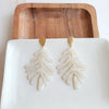Shop Palm Earrings - Seashell Cream-Seashell cream palm leaf earrings with gold accents. Lightweight, tropical-inspired statement style—perfect for vacations, summer events, or everyday chic.-available at Reef Love online boho-chic boutique