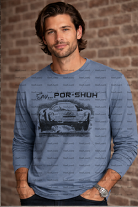 Man wearing a blue long-sleeve shirt with a PORSCHE 396 graphic and text against a brick wall.