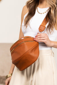 Oversized Leather Crescent Sling. Vegan leather crossbody sling, multiple zip pockets, adjustable strap, and gold hardware.