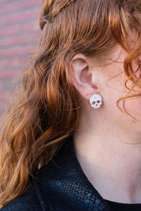 Shop Skull Studs - White Glitter-White glitter skull stud earrings made from lightweight acrylic with hypoallergenic posts. A sparkling, spooky touch for Halloween or fun everyday edgy style.-available at Reef Love online boho-chic boutique